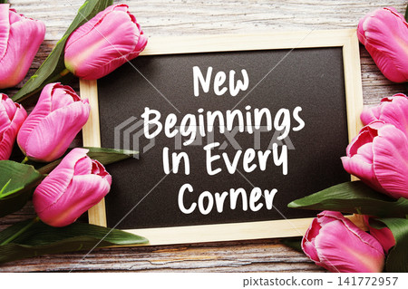 New Beginnings In Every Corner text written on notepad with flower decoration on wooden background 141772957