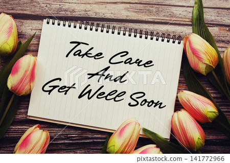 Take Care And Get Well Soon text written on notepad with flower decoration on wooden background Take Care And Get Well Soon text written on notepad with flower decoration on wooden background 141772966