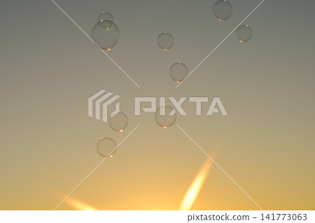 Soap bubbles floating in the sunset sky Soap bubbles floating in the sunset sky 141773063