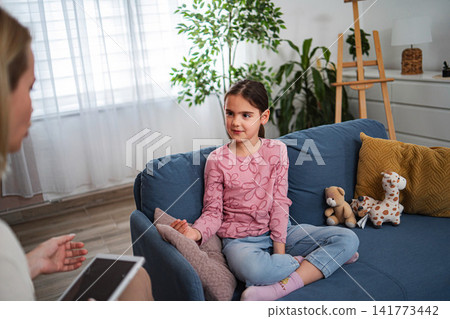 Child communicating with psychologist during counseling session 141773442