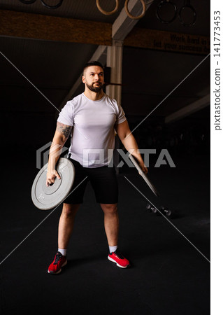 Strong man training with weights in gym Strong man training with weights in gym 141773453