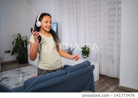 Girl listening music and dancing with smartphone Girl listening music and dancing with smartphone 141773476