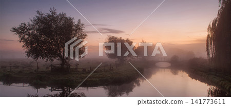 Misty River Sunrise with Tree Silhouettes and Reflections Misty River Sunrise with Tree Silhouettes and Reflections 141773611
