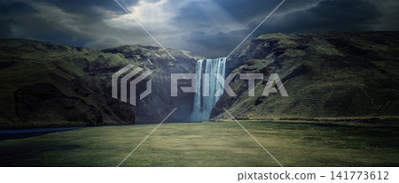 Dramatic Waterfall in Green Mountain Valley Under Stormy Sky Dramatic Waterfall in Green Mountain Valley Under Stormy Sky 141773612