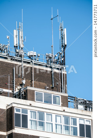 Corby, Northamptonshire, UK - August 2, 2026: Telecommunications antennas on rooftop of office building in Corby, England 141773711
