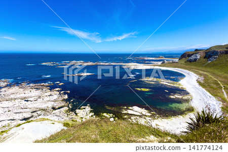 Coastal Landscape with Blue Ocean, Rocky Shore, and White Sand Beach Coastal Landscape with Blue Ocean, Rocky Shore, and White Sand Beach 141774124