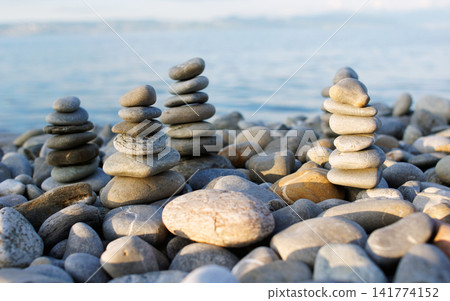 Zen Stacked Stones on Pebble Beach by Calm Ocean Zen Stacked Stones on Pebble Beach by Calm Ocean 141774152