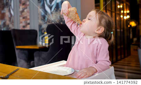 Toddler Girl Devouring Pizza At Cafe, Pink Sweater And High Chair, Sauce On Chin, Playful Expression, Warm Ambient Lights And Cozy Interior, Candid Family Dining Moment Full Of Joy And Mess Toddler Girl Devouring Pizza At Cafe, Pink Sweater And High Chair, Sauce On Chin, Playful Expression, Warm Ambient Lights And Cozy Interior, Candid Family Dining Moment Full Of Joy And Mess 141774392