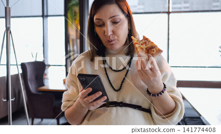 Woman Entertains While Eating Lunch. Female Professional Responds To Messages While Enjoying Pizza And Working. Woman Balances Her Smartphone Response Duties And Pizza Snack During Brief Cafe Break Woman Entertains While Eating Lunch. Female Professional Responds To Messages While Enjoying Pizza And Working. Woman Balances Her Smartphone Response Duties And Pizza Snack During Brief Cafe Break 141774408