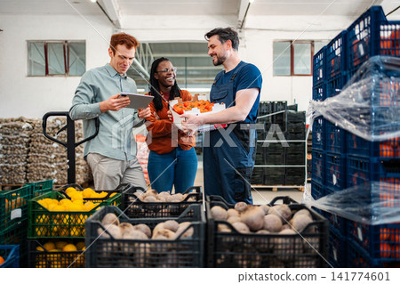 Produce team checking fresh vegetables in warehouse Produce team checking fresh vegetables in warehouse 141774601