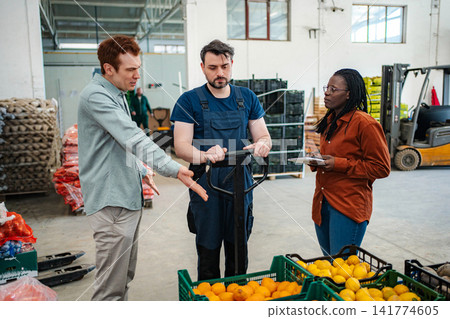 Warehouse workers discussing logistics and fresh fruit inventory Warehouse workers discussing logistics and fresh fruit inventory 141774605