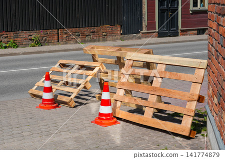 Wooden Shipping Pallets and Traffic Cones Blocking Sidewalk During Street Construction Safety Work Area Wooden Shipping Pallets and Traffic Cones Blocking Sidewalk During Street Construction Safety Work Area 141774879