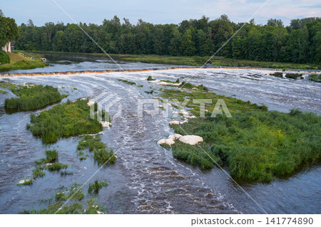 Ventas Rumba Waterfall on the Venta River in Kuldiga Latvia Surrounded by Lush Summer Nature Landscape Ventas Rumba Waterfall on the Venta River in Kuldiga Latvia Surrounded by Lush Summer Nature Landscape 141774890