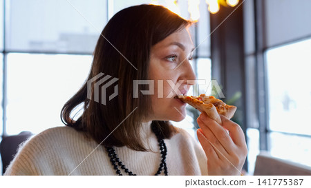 Peaceful Woman Relishing Quiet Snack Outside. Calm And Introspective Woman Enjoying Her Food And Scenic View. Thoughtful Lady Takes Peaceful Bite Of Pizza While Gazing Beyond Cafe Window Peaceful Woman Relishing Quiet Snack Outside. Calm And Introspective Woman Enjoying Her Food And Scenic View. Thoughtful Lady Takes Peaceful Bite Of Pizza While Gazing Beyond Cafe Window 141775387