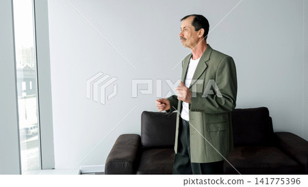 Man Standing Near Window dancing, Looking Out At Skyline With Thoughtful Expression, Poised Leadership Aura, Strategic Planning And Forward Thinking In Contemporary Office Environment Man Standing Near Window dancing, Looking Out At Skyline With Thoughtful Expression, Poised Leadership Aura, Strategic Planning And Forward Thinking In Contemporary Office Environment 141775396
