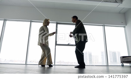 Joyful Dance In Office Space. Professionals Joyfully Dancing After Achieving Important Milestone. Energetic Professionals In Silhouette Performing Celebratory Dance In Modern Office Environment Joyful Dance In Office Space. Professionals Joyfully Dancing After Achieving Important Milestone. Energetic Professionals In Silhouette Performing Celebratory Dance In Modern Office Environment 141775397