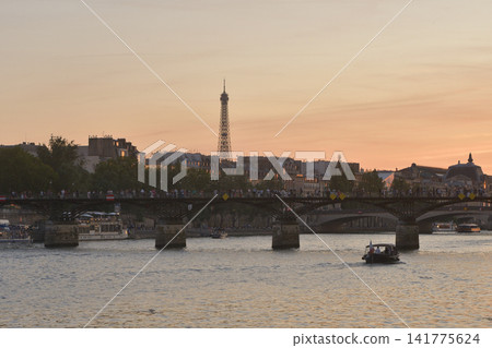 A view of the Seine River, the Pont des Arts, and the Eiffel Tower bathed in the twilight. Photographed on June 17, 2026, in Paris, France. A view of the Seine River, the Pont des Arts, and the Eiffel Tower bathed in the twilight. Photographed on June 17, 2026, in Paris, France. 141775624