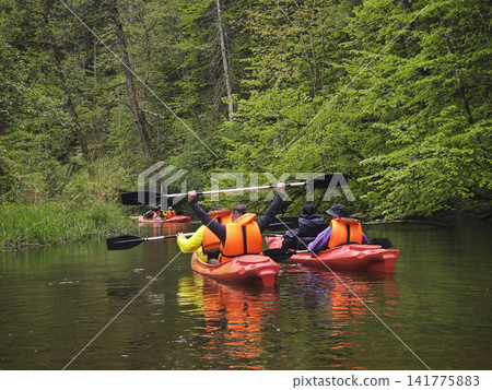 POV from a yellow kayak as paddlers in life jackets POV from a yellow kayak as paddlers in life jackets 141775883