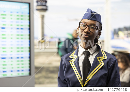 Woman flight attendant, in airline uniform, walking through airport terminal and being ready for takeoff. Aviation personnel highlighting professionalism and air travel quality industry. 141776438