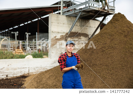 Young woman holding handful of dung 141777242