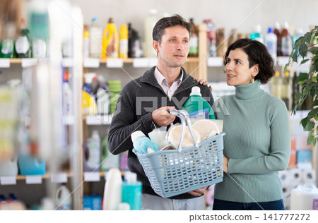 Married couple with basket in supermarket Married couple with basket in supermarket 141777272
