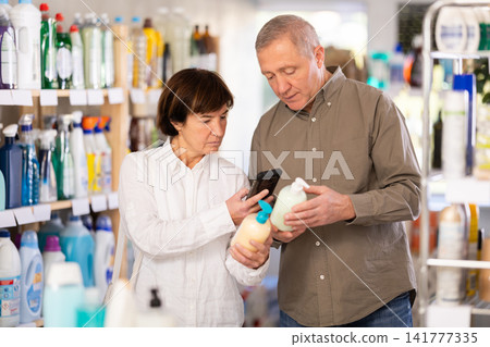 Couple man and woman scanning qr code for liquid soap Couple man and woman scanning qr code for liquid soap 141777335