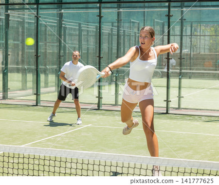Sports woman and man playing padel on tennis court 141777625