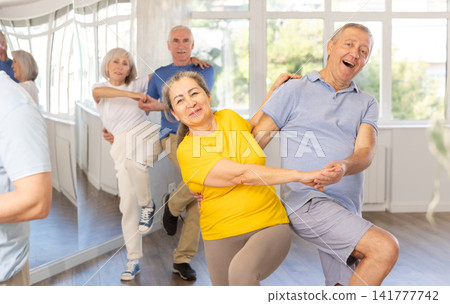 Cheerful elderly amateur couple dancing lindy hop at choreography class Cheerful elderly amateur couple dancing lindy hop at choreography class 141777742