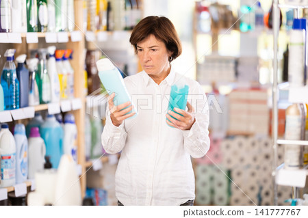 Elderly woman choosing shampoo or shower gel in store Elderly woman choosing shampoo or shower gel in store 141777767