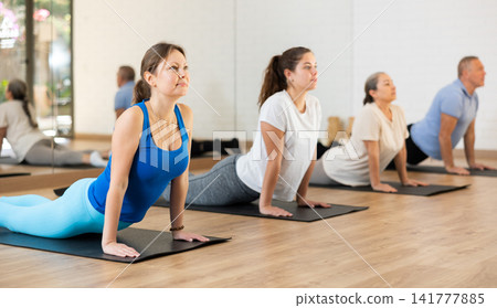 Woman doing Upward Facing Dog pose during yoga workout 141777885