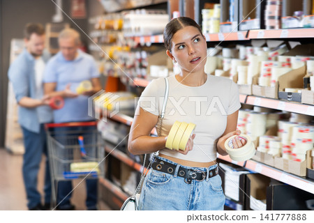 Young woman choosing building tape in store Young woman choosing building tape in store 141777888