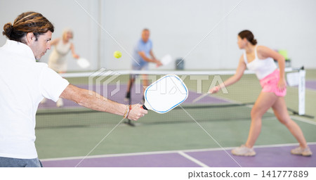 Paddle-shaped racquet for pickleball in hand of male player Paddle-shaped racquet for pickleball in hand of male player 141777889