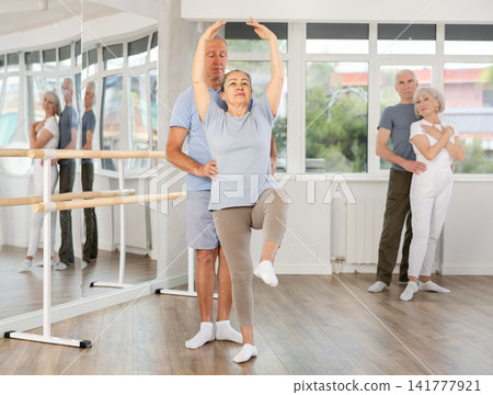 Elderly couples learning to dance ballet in dance studio Elderly couples learning to dance ballet in dance studio 141777921