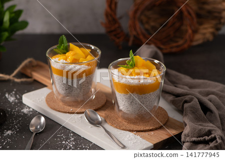 Two Glass Cups of Chia Seed Pudding Layered with Mango Puree and Fresh Mint Two Glass Cups of Chia Seed Pudding Layered with Mango Puree and Fresh Mint 141777945