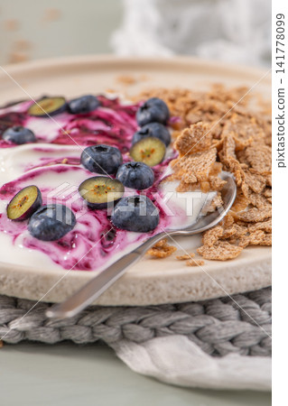 Healthy breakfast bowl with yogurt, berry compote, blueberries and cereal 141778099