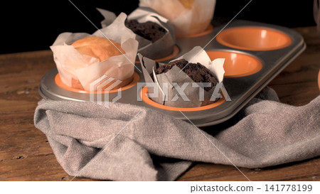 Freshly baked assorted muffins in a muffin tin Freshly baked assorted muffins in a muffin tin 141778199
