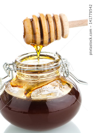 Jar of honey with wooden drizzler Jar of honey with wooden drizzler 141778542