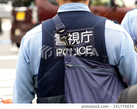 東京街頭,一名警察斜背包包執勤。 東京街頭,一名警察斜背包包執勤。 141778834