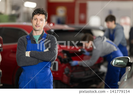 Portrait of a positive girl auto mechanic in the interior of car service Portrait of a positive girl auto mechanic in the interior of car service 141779154