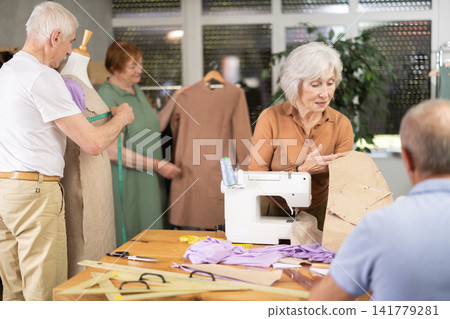 Woman discussing pattern with classmate during sewing course for older adults Woman discussing pattern with classmate during sewing course for older adults 141779281