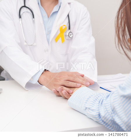 doctor holding patient hand to comfort and support with empathy for Yellow Ribbon concept of yellow September, Suicide prevention day, Childhood, July Sarcoma, bone and bladder cancer Awareness month doctor holding patient hand to comfort and support with empathy for Yellow Ribbon concept of yellow September, Suicide prevention day, Childhood, July Sarcoma, bone and bladder cancer Awareness month 141780471