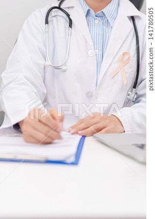 doctor using laptop and report notes on notebook. peach ribbon concept of September Uterine Cancer Awareness month, Endometrial, Gynecologic, Uterus and Ovaries, Endometriosis, June Vaginal cancer doctor using laptop and report notes on notebook. peach ribbon concept of September Uterine Cancer Awareness month, Endometrial, Gynecologic, Uterus and Ovaries, Endometriosis, June Vaginal cancer 141780505
