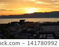A winter evening scene of the sea and a harbor with ships anchored. 141780992