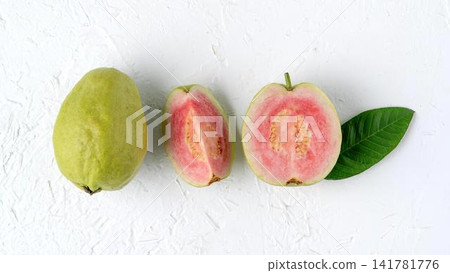 Fresh guava fruit whole and sliced with leaf on white background Fresh guava fruit whole and sliced with leaf on white background 141781776