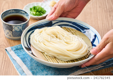 Zaru Udon: A cold noodle dish made with Sanuki udon noodles served on a plate. Zaru Udon: A cold noodle dish made with Sanuki udon noodles served on a plate. 141782345