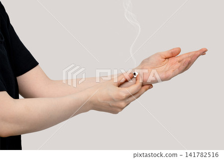 一名女子用上半身支撐著手腕上的艾灸治療,手指正放在手腕上。 一名女子用上半身支撐著手腕上的艾灸治療,手指正放在手腕上。 141782516