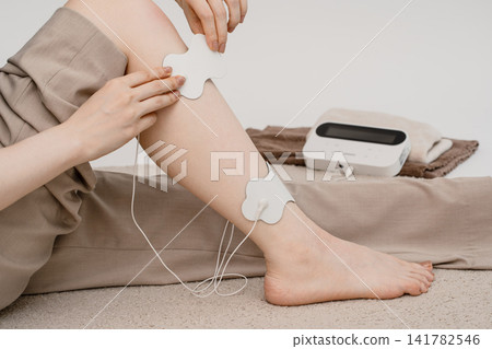 一名女子腿部的兩個部位貼有電極片。 一名女子腿部的兩個部位貼有電極片。 141782546