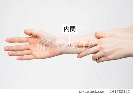 A woman points to the Neiguan acupoint on her wrist. A woman points to the Neiguan acupoint on her wrist. 141782595
