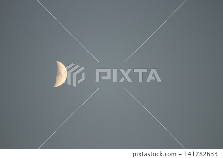 一輪潔白的月亮漂浮在暮色的天空。 一輪潔白的月亮漂浮在暮色的天空。 141782633
