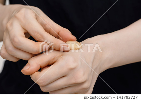 姜灸療法是將薑片放在女性手背上。 姜灸療法是將薑片放在女性手背上。 141782727